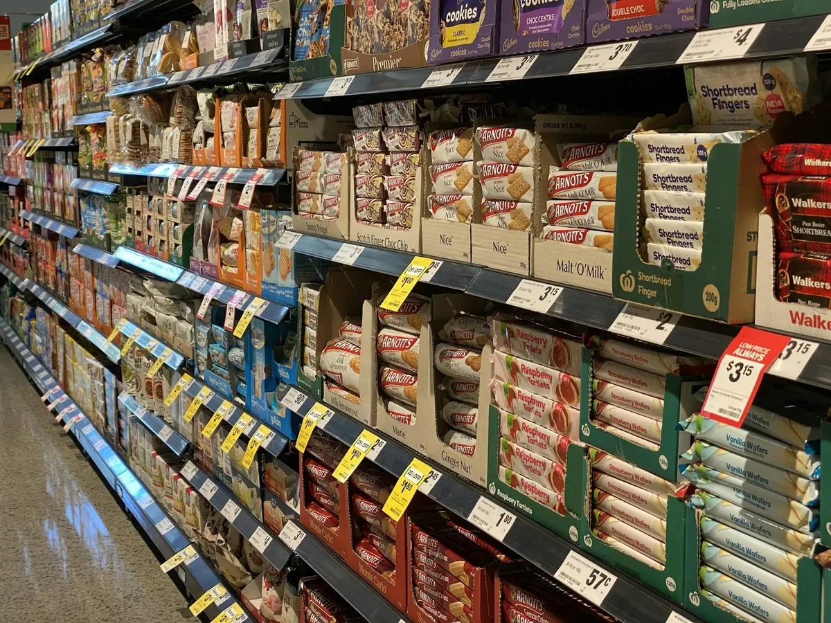 Gôndola de supermercado com produtos embalados e etiquetas de preço