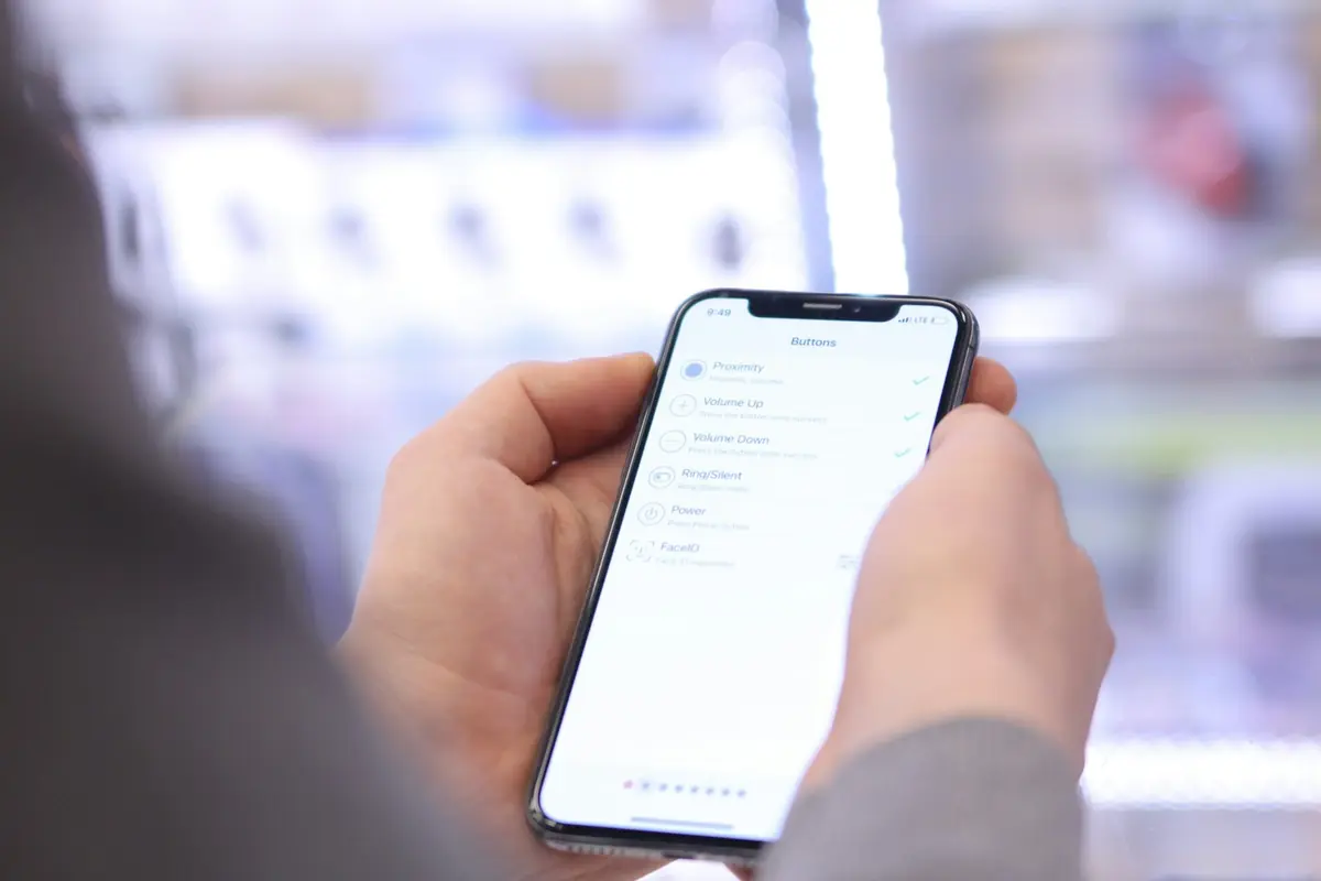 Mão usando um smartphone em uma loja iluminada